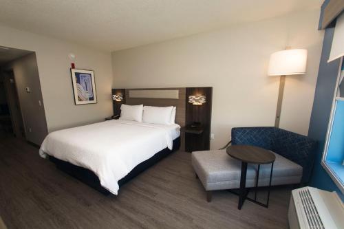 a hotel room with a bed and a table and a chair at Holiday Inn Express & Suites Cocoa by IHG in Cocoa