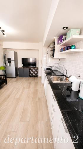a kitchen with white cabinets and black counter tops at Nice Full Apartments Downtown Salta in Salta