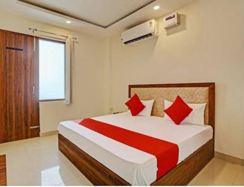 a bedroom with a large bed with red pillows at Fab Krishna hotal in Panchkula
