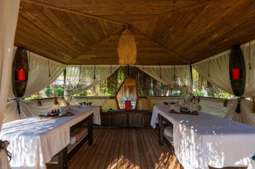 a dining room with two tables with white table cloth at Odile Hotel by Naturelife in Cıralı