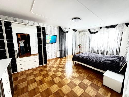 a bedroom with a bed and a wooden floor at Two bedroom in Park Zone in Kamianets-Podilskyi