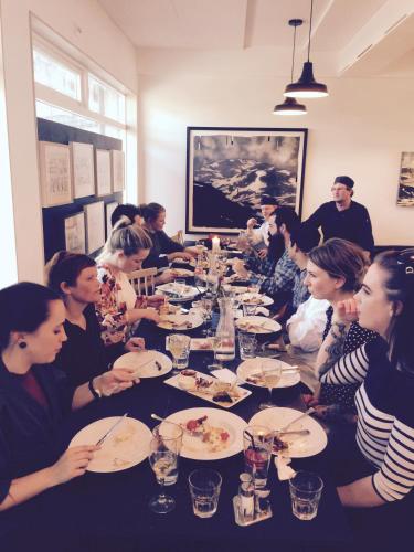 a group of people sitting at a long table eating at Fugl Fønix Hotel in Etnesjøen