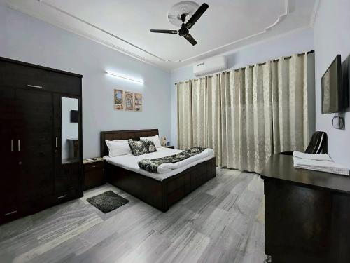 a bedroom with a bed and a ceiling fan at Kanwar Homestay in Amritsar