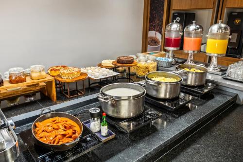 a kitchen with pots and pans of food on a stove at Slim Hotel Campinas in Campinas