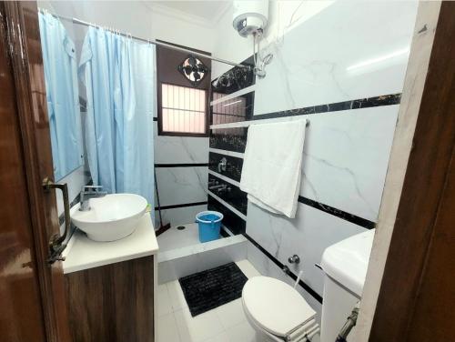 a white bathroom with a sink and a toilet at Kanwar Homestay in Amritsar