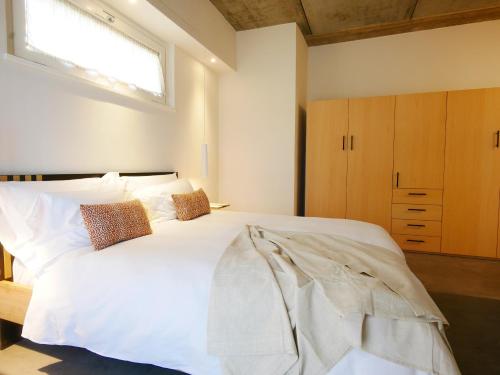 a bedroom with a large white bed with a window at Restorative stay Garden Jacuzzi Lake View in Lierna