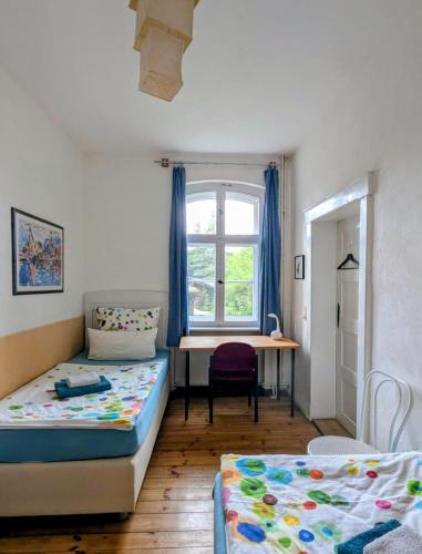 a bedroom with two beds and a desk and a window at Pirol in Niederfinow