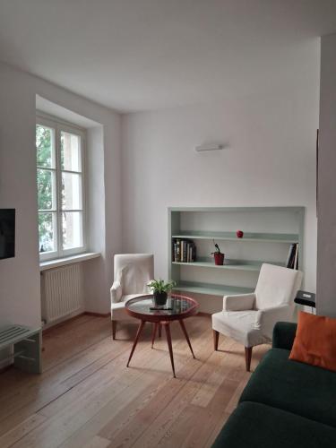 a living room with a green couch and a table at Vicolo al Duomo in Trento