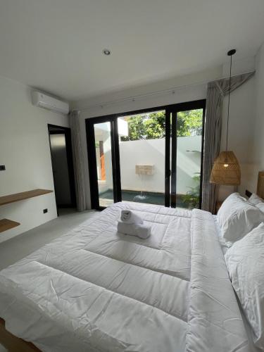 a large white bed in a bedroom with a large window at Villa Rosa Dreams 2 in Ungasan