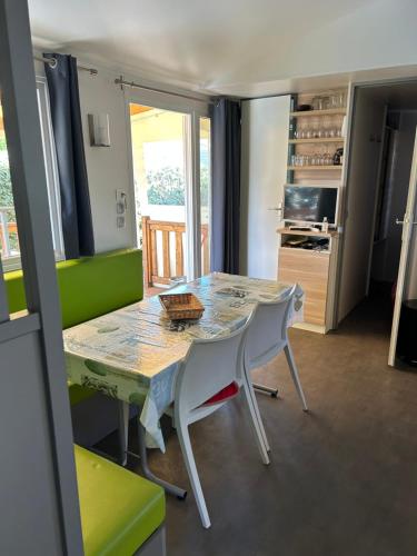 a dining room with a table and two chairs at Mobil-home Messanges in Messanges