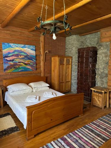 a bedroom with a bed and a painting on the wall at Будинок Художника in Synevyrsʼka Polyana