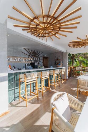 a restaurant with a bar with tables and chairs at The Beach House Boutique Hotel in West End