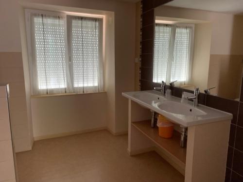 a bathroom with a sink and two windows at Les chambres de Fred in Gorses
