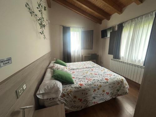 a small bedroom with a bed with green pillows at Hotel Rural Rio Molinar - ADULTS ONLY in Ranera