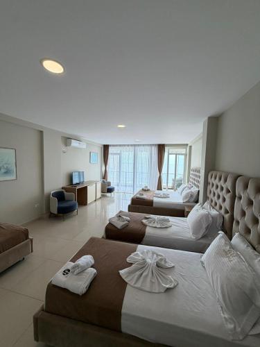 a hotel room with two beds and a living room at Gjilani Premium Hotel in Shëngjin