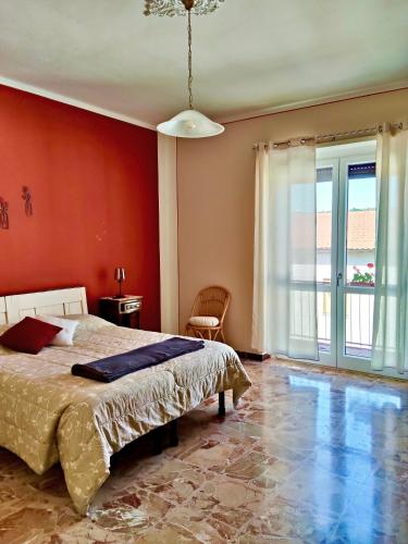a bedroom with a bed and a red wall at Affittacamere San Rocco in Aramengo