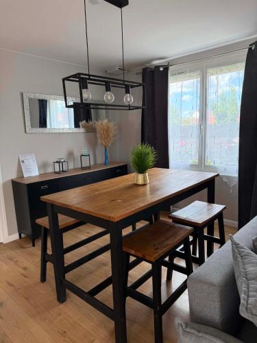 a living room with a table and a couch at Maison 2 chambres avec jardin et parking privatif in Saran