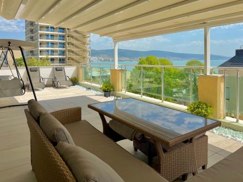 a patio with a table and chairs on a balcony at Premium Apartment Midia Beach in Sunny Beach