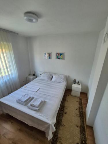 a bedroom with a white bed with towels on it at Kosmaj Casa Maia in Dučina
