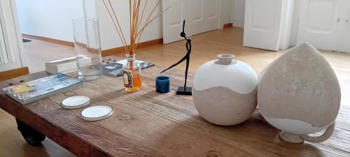 ein Holztisch mit Vasen und anderen Gegenständen darauf in der Unterkunft Madama in Bari