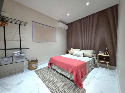 a bedroom with a bed with a red blanket at Petit Paradise in Noord