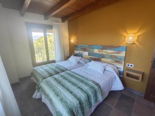 a bedroom with two beds and a window at Casa Cosculluela in Aínsa