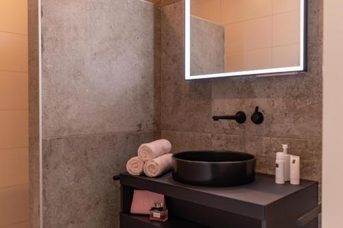 a bathroom with a sink and a mirror and towels at De Hooiberg in Ritthem
