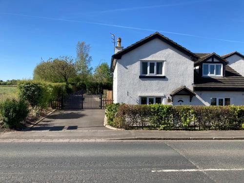 a white house on the side of a street at Primrose Cottage Westhead in Westhead