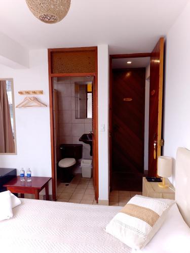 a bedroom with a bed and a door to a bathroom at VIVEMAR PUNTA HERMOSA - Beach House Lima - Perú in Punta Hermosa