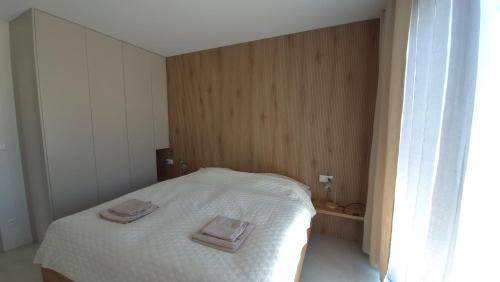 a bedroom with a bed with two towels on it at Apartman Bartimej 2 in Bobrów
