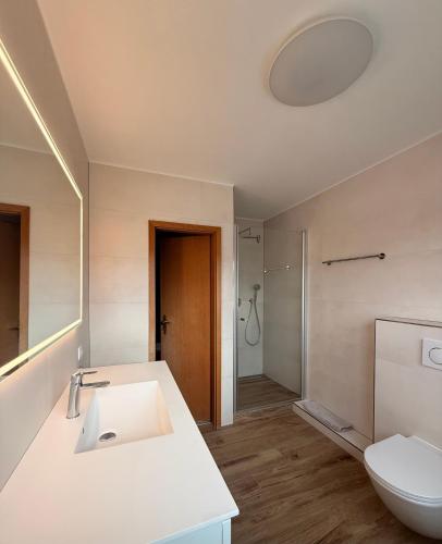 a bathroom with a white sink and a toilet at Ferienwohnung Meeressand in Böhl