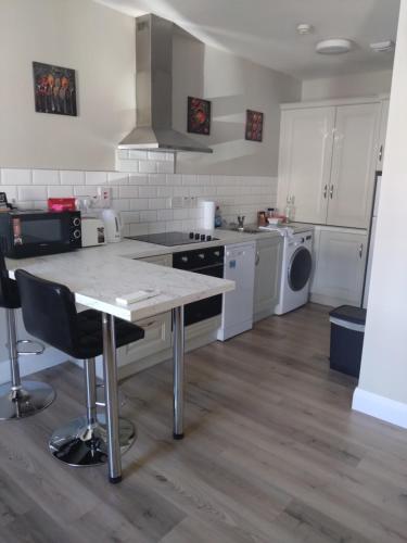 a kitchen with a table and a stove top oven at Codladh Sámh Apartment No 1 in Templemore