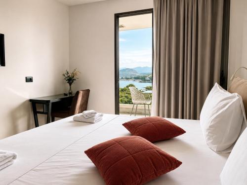 a bedroom with a bed and a desk and a window at Delight Hotel in Ksamil