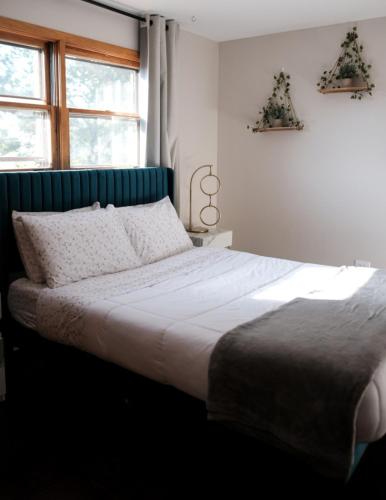 a bedroom with a large white bed with a blue headboard at 3BR Modern Apt • Gym • Workspace • Quiet Location in Chicago
