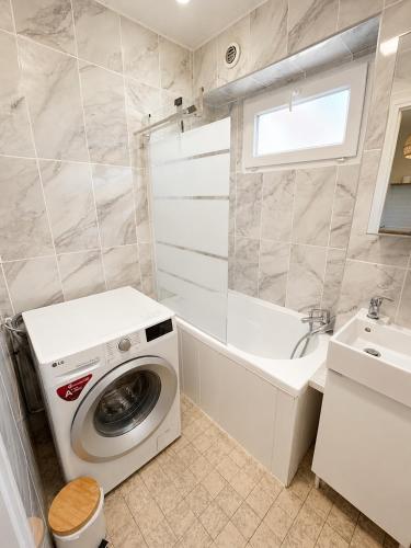 a bathroom with a washing machine and a sink at La Petite Luce in Le Vaudreuil