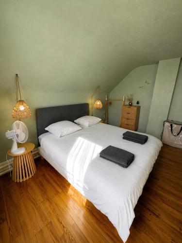 a bedroom with a large bed with two towels on it at La Petite Luce in Le Vaudreuil