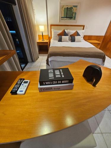 a room with a bed and two books on a table at Flat na praia da Barra 2 in Rio de Janeiro