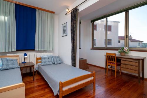 a bedroom with two beds and a desk and window at Moonvidal residence with big private swimming pool and free parking in Pula
