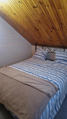 a bed in a room with a wooden ceiling at Chalet à la campagne 40m2 in Charleval