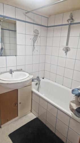 a bathroom with a tub and a sink and a bath tub at Chalet à la campagne 40m2 in Charleval