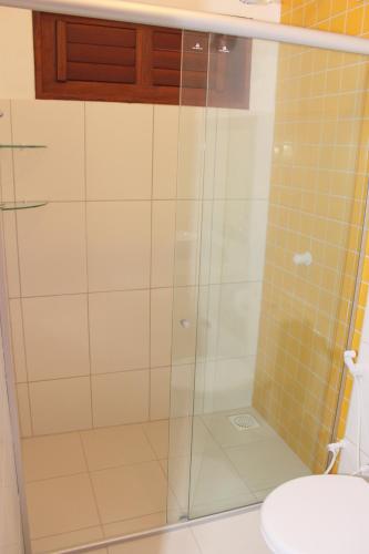 a shower with a glass door in a bathroom at Pousada Paraíso dos Ipês in Jijoca de Jericoacoara