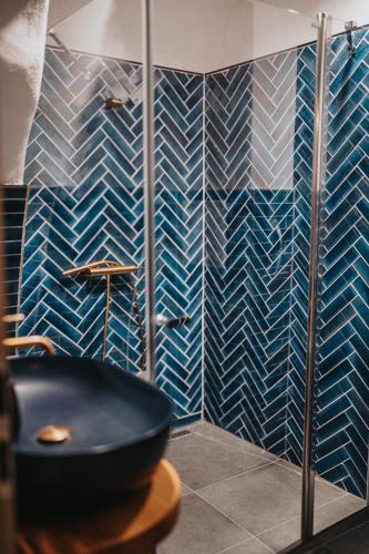 a bathroom with a black sink and blue tiles at genius loci apartments in Levoča