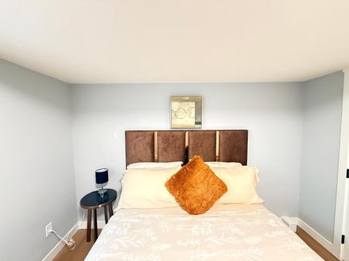 a bedroom with a bed with a brown pillow on it at 2 bedroom Cozy Secondary-Basement suite in Calgary