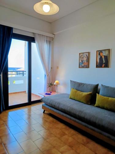 a living room with a bed and a glass door at Ostria Apartments Kalives in Kalyves
