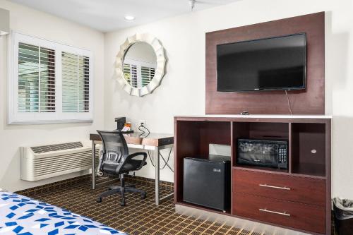a bedroom with a desk and a television on a wall at Hotel Solares in Santa Cruz