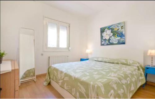 1 dormitorio con cama, espejo y ventana en Sea Apartament, en Sant Adrià de Besòs