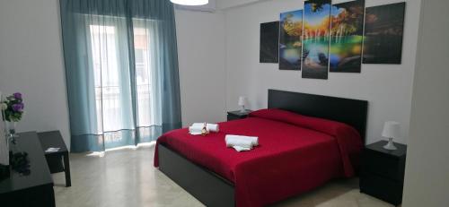 a bedroom with a red bed with two pillows on it at Brezza di Mare in Finale