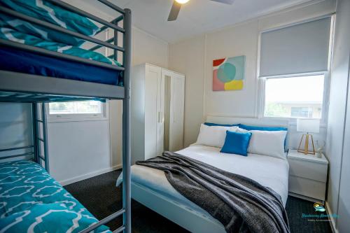 een slaapkamer met een stapelbed met blauwe kussens bij Breakaway Moonta Bay in Port Moonta