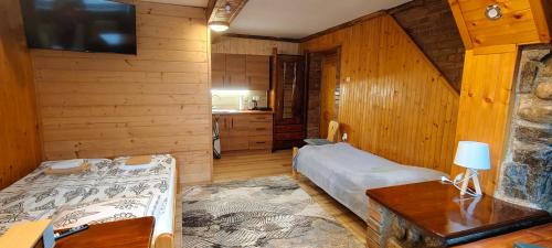a bedroom with a bed and a table and a tv at Apartamenty u drwala in Zakopane