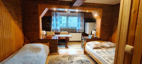 a room with two beds and a table in a room at Apartamenty u drwala in Zakopane